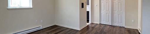 A room with wooden floors and a white door.