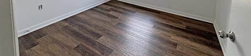 A room with wooden flooring and a window.