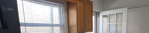 A kitchen with a black stove top oven, wooden cabinets, and a black dishwasher.