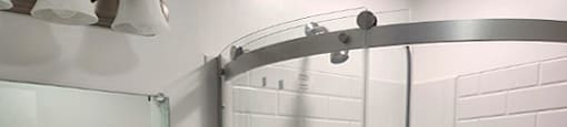 A white tiled bathroom with a sink and a shower.