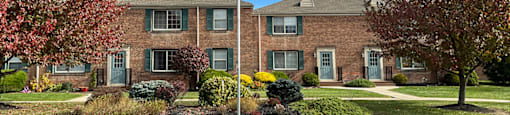 A flag is flying in front of a building with a green lawn in front of it.