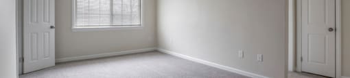 the living room of an empty house with a window and a door
