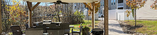 A patio with a table and chairs under a roof.