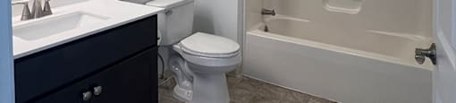 A white bathroom with a sink, toilet, and bathtub.