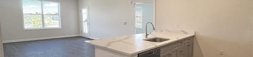 an empty kitchen with an island and a window