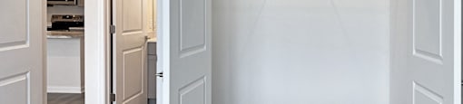 a bedroom with a closet and a door to a kitchen