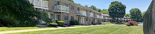 A row of apartment buildings with green lawns in front.