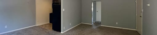 A room with a carpeted floor and a ceiling fan.