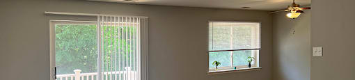 A room with a carpeted floor and a ceiling fan.