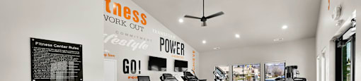 A gym with a treadmill, exercise bike and other equipment.