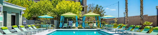 A large swimming pool with lounge chairs and umbrellas.