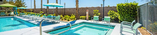 A pool area with palm trees and sun loungers.