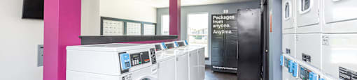 a laundry room with washers and dryers and a row of washing machines at Cadence Apartments, Roy, 84103