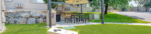 a backyard with a picnic area and a table with food on it at Mountain Run Apartments, Orem, Utah, 84058