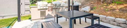 a patio with a table and chairs with an umbrella at Mountain Run Apartments, 84058