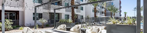 A modern outdoor seating area with white chairs and tables.