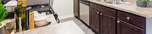 A kitchen with brown cabinets and a stove top oven.