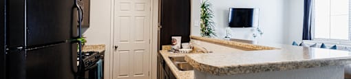 a kitchen with a counter top and a refrigerator at CHANDLER APARTMENT HOMES, Las Vegas, Nevada