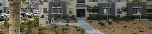 an exterior view of an apartment complex with a sidewalk and a tree at CHANDLER APARTMENT HOMES, Las Vegas, NV, 89139