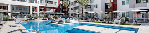 A swimming pool in front of apartment buildings.
