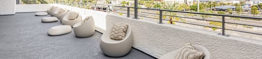 A series of white couches are lined up on a patio.
