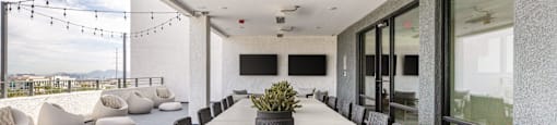 A modern dining room with a long table and chairs.