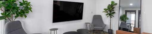 a living room with a couch chairs and a tv on the wall at DOCK 59 APARTMENTS, PORTLAND, Oregon