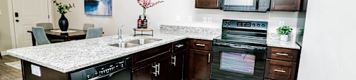a kitchen with stainless steel appliances and a counter top at Arcadia Townhomes, Roy, UT 84067