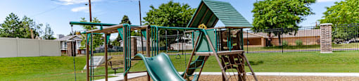 a playground with a slide at a park at Arcadia Townhomes, Roy Utah