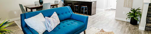 a living room and kitchen with a blue couch at Arcadia Townhomes, Utah