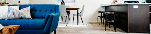 a living room and kitchen with a blue couch at Arcadia Townhomes, Roy, 84067