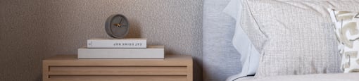 A bedroom with a bed, nightstand, and lamp.