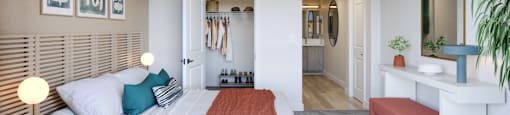 A bedroom with a bed, a bench, and a mirror.