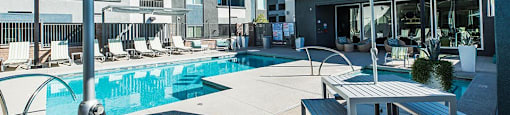 Pool with seating and lounge chairs at THE RISE APARTMENT HOMES, Nevada
