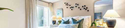 A bedroom with a large bed and a mirror on the wall.