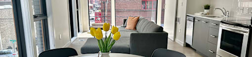 a kitchen and living room with a table and chairs and a large window at DOCK 59 APARTMENTS, PORTLAND, Oregon