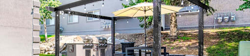 a patio with a table and chairs under a canopy at Mountain Run Apartments, Orem, 84058