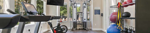a gym with a treadmill and weights and a tv at Ascent Apartments, Cottonwood Heights, UT 84121