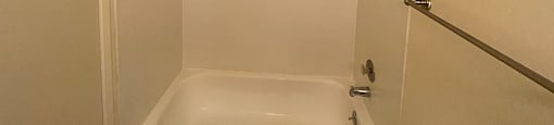 a white bath tub sitting next to a shower at OTAVON APARTMENTS, Novato, CA