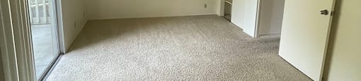 an empty room with a sliding glass door and a door to a balcony at OTAVON APARTMENTS, Novato California