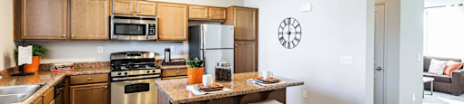 a kitchen with wooden cabinets and a table with chairs at EVERETT APARTMENT HOMES, Las Vegas, Nevada