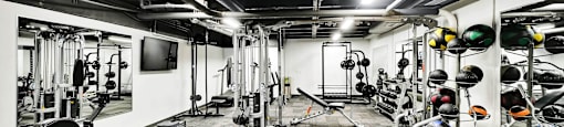 A gym with a variety of equipment including weights and a tire.