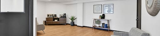 A room with a grey sofa and a wooden floor.