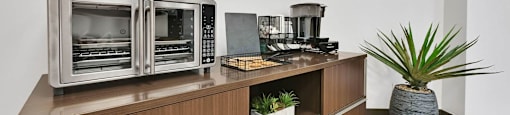 A modern kitchen with a wooden cabinet and a stainless steel oven.