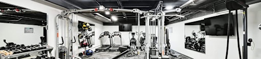 A black and white photo of a gym with various exercise equipment.