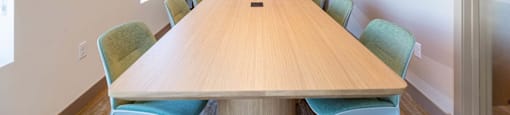 A conference room with a long table and chairs.