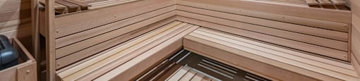 A wooden sauna with benches and a heater.