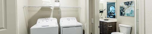 Washer and dryer with view of bathroom at THE RISE APARTMENT HOMES, Las Vegas, Nevada
