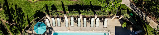 a birds eye view of a pool and patio with umbrellas and tables at SERRANO HIGHLANDS APARTMENT HOMES, California, 92630-7006