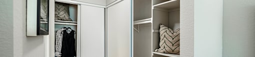 a closet in a bedroom with a mirrored closet door at SYCAMORE GREENS APARTMENT HOMES, Vista, 92081
